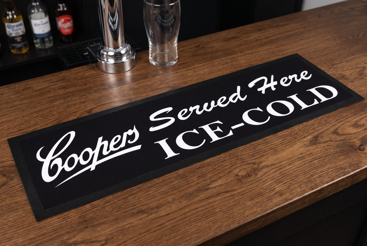 Coopers "Served Here Ice Cold" Premium Rubber-Backed Bar Mat Runner on a bar top