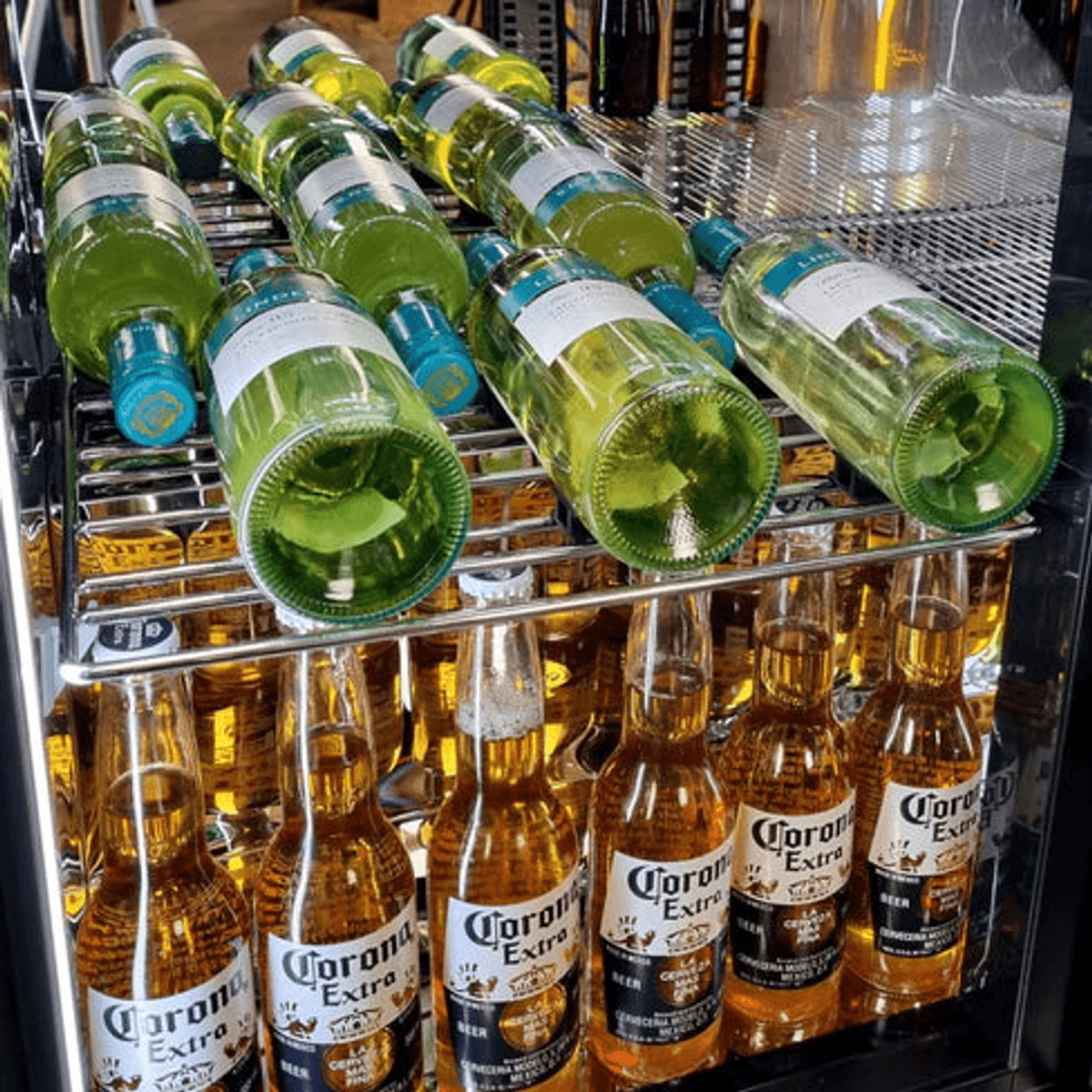 Chromed wine shelf holding bottles horizontally inside a bar fridge