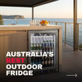 Rhino ENV 316 marine grade outdoor bar fridge built into the cabinetry of a coastal balcony bar at golden hour, ocean and headland behind