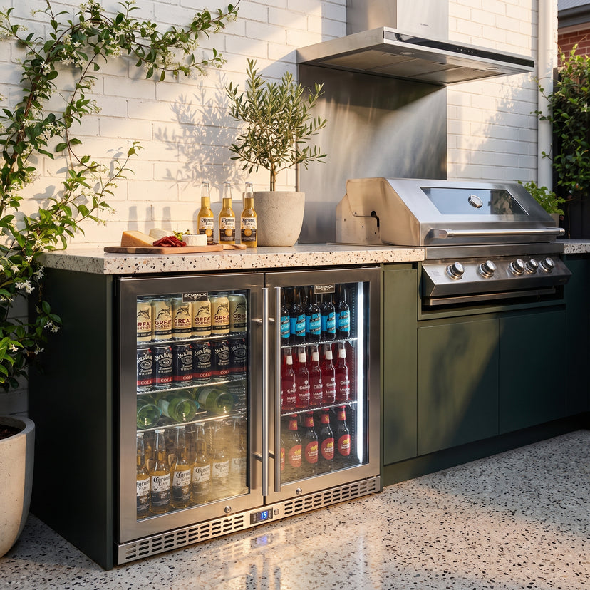 Schmick SK246-HD bar fridge built into an outdoor kitchen: courtyard kitchen with terrazzo and green cabinets, stainless bbq and rangehood